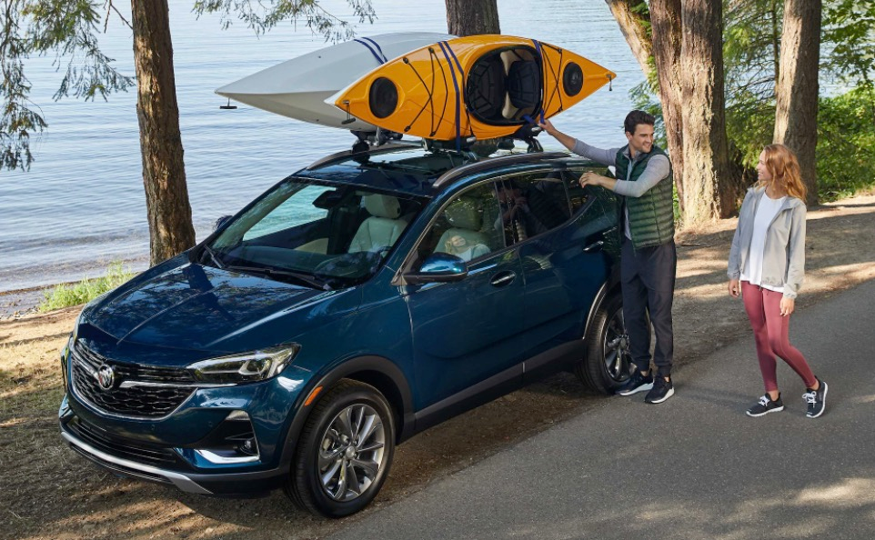 A couple unpack kayaks from the top of their encore GX