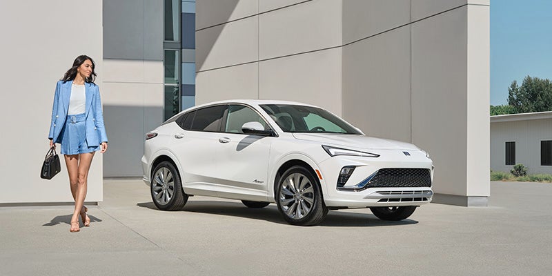 White Envista parked front of building and a women is walking near car with holding a bag in hand