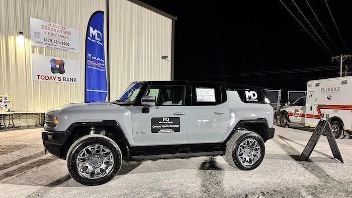Gray Hummer EV with McLarty Daniel logo at Pea Ridge football stadium